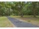Asphalt pathway winds through a shady, wooded area at 1136 Brick Rd, Winter Garden, FL 34787