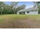 White house exterior with covered patio, green lawn and large backyard at 1136 Brick Rd, Winter Garden, FL 34787