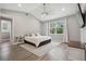 Bright bedroom with a king-size bed, wood-look floors, and large window at 1136 Brick Rd, Winter Garden, FL 34787