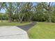 Curved pathway through a wooded area, with green grass and trees at 1136 Brick Rd, Winter Garden, FL 34787