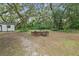 Spacious backyard with a wooden table and chairs, set amongst the trees at 1136 Brick Rd, Winter Garden, FL 34787