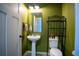 Small bathroom with pedestal sink and green walls at 11430 Wishing Well Ln, Clermont, FL 34711