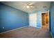Spacious bedroom with ceiling fan and access to a hallway at 11430 Wishing Well Ln, Clermont, FL 34711