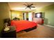 Main bedroom with red bedding and large TV at 11430 Wishing Well Ln, Clermont, FL 34711