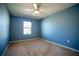 Blue bedroom with ceiling fan and window at 11430 Wishing Well Ln, Clermont, FL 34711