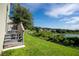 View of backyard, wooden deck, and pond with houses in the distance at 11430 Wishing Well Ln, Clermont, FL 34711