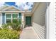Side view of the house entryway with teal door and walkway at 11394 Zimmerman Path, Oxford, FL 34484