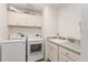 Bright laundry room, featuring LG washer and dryer, and upper cabinets at 11394 Zimmerman Path, Oxford, FL 34484
