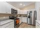 Modern kitchen with white cabinets, granite countertops, and stainless steel appliances at 11394 Zimmerman Path, Oxford, FL 34484