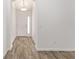 Clean hallway with wood-look flooring leading to another room at 11394 Zimmerman Path, Oxford, FL 34484