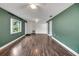Living room features hardwood floors and green accent walls at 11635 Se Highway 42, Weirsdale, FL 32195