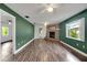 Open living room with wood-look floors and green walls at 11635 Se Highway 42, Weirsdale, FL 32195