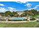 Resort-style pool with lush landscaping and clubhouse in background at 3506 Mulberry Grove Loop, Leesburg, FL 34748