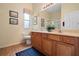 Bathroom with double sinks, wood cabinets, and a shower at 3506 Mulberry Grove Loop, Leesburg, FL 34748