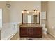 Bathroom with granite countertops, double sinks, and a garden tub at 3912 Plantation Blvd, Leesburg, FL 34748