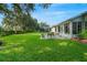 Spacious backyard with a patio, lush lawn, and mature trees at 3912 Plantation Blvd, Leesburg, FL 34748