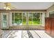 Sunroom with tiled floors, large windows showcasing a lush green view, and a ceiling fan at 3912 Plantation Blvd, Leesburg, FL 34748