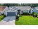 Single-story home with a gray garage door and a compass-designed driveway at 3912 Plantation Blvd, Leesburg, FL 34748