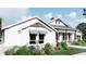 White two-story house with gray roof, landscaping, and a walkway at 450 Long And Winding Rd, Groveland, FL 34737