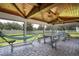 Screened porch with table, benches, and hammock at 7425 Lake Marni Ct, Mount Dora, FL 32757