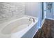 Bathroom with an oval soaking tub and stone tile surround at 7425 Lake Marni Ct, Mount Dora, FL 32757