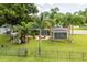 Landscaped backyard with patio, pergola, and palm trees at 7425 Lake Marni Ct, Mount Dora, FL 32757