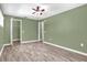 Bedroom with wood-look floors, closet, and ceiling fan at 1500 Cobble Ln, Mount Dora, FL 32757