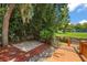 Brick patio area with red mulch and a view of a tranquil pond at 507 Lakeshore Dr, Eustis, FL 32726