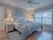 King-size bed, light wood furniture, and wood floors in this bright bedroom at 616 Cokesbury Dr, The Villages, FL 32162