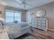 Bedroom with king-size bed, light wood furniture, and wood flooring at 616 Cokesbury Dr, The Villages, FL 32162