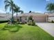 Cute house with a well-manicured lawn and palm trees at 616 Cokesbury Dr, The Villages, FL 32162
