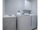 Laundry room with washer, dryer, cabinets, and utility sink at 616 Cokesbury Dr, The Villages, FL 32162