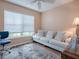 Bright home office features a comfy sofa, large window, and hardwood floors at 616 Cokesbury Dr, The Villages, FL 32162