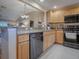 Kitchen boasts wood cabinets, granite counters, and stainless steel appliances at 616 Cokesbury Dr, The Villages, FL 32162