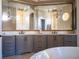 Elegant bathroom with double vanity, soaking tub, and large mirror at 15008 Pendio Dr, Bella Collina, FL 34756