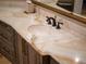 Close-up of a bathroom vanity with onyx countertop and modern fixtures at 15008 Pendio Dr, Bella Collina, FL 34756