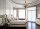 Bright bedroom with a large bed, dark hardwood floors, and a modern chandelier at 15008 Pendio Dr, Bella Collina, FL 34756
