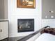 Modern fireplace with white surround and wood mantle in a bedroom at 15008 Pendio Dr, Bella Collina, FL 34756