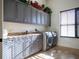 Laundry room with gray cabinets, granite countertop, and washer/dryer at 15008 Pendio Dr, Bella Collina, FL 34756