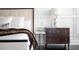 Dark brown nightstand with gold drawer pulls next to a bed at 15008 Pendio Dr, Bella Collina, FL 34756