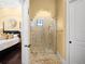 Walk-in shower with glass enclosure and stone tile at 15008 Pendio Dr, Bella Collina, FL 34756