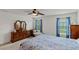 Bright bedroom with double windows, ceiling fan, and wood dresser at 736 Jones Ln, The Villages, FL 32163