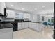 Modern kitchen with white cabinets, black countertops and appliances at 3401 Fairfield St, The Villages, FL 32162
