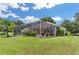 Landscaped backyard featuring a screened pool and patio area at 5515 Citation Ct, Lady Lake, FL 32159