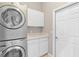 Laundry room with stackable washer and dryer, cabinets, and extra storage at 5515 Citation Ct, Lady Lake, FL 32159