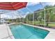 Refreshing screened pool with spa and lush backyard views at 5515 Citation Ct, Lady Lake, FL 32159