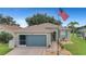 House exterior, gray with blue garage door, American flag at 32915 Crooked Oaks Ln, Leesburg, FL 34748