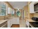 Kitchen with white cabinets, stainless steel appliances and view of backyard at 32915 Crooked Oaks Ln, Leesburg, FL 34748