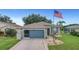 House exterior, gray with blue garage door, American flag at 32915 Crooked Oaks Ln, Leesburg, FL 34748
