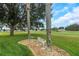 Landscaped backyard with a bench and golf course view at 32915 Crooked Oaks Ln, Leesburg, FL 34748